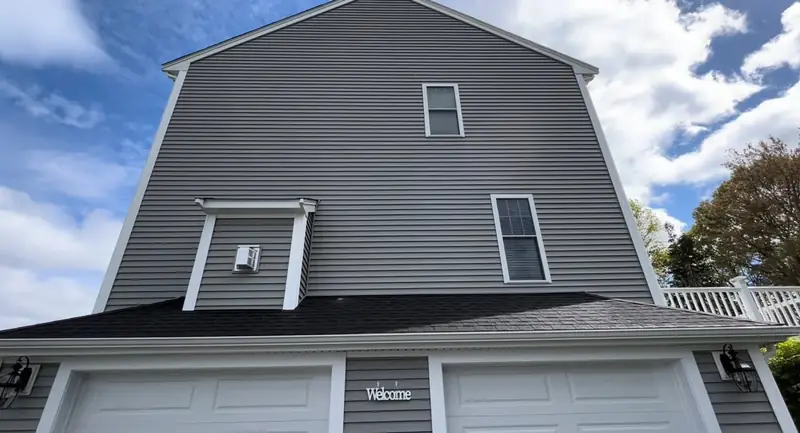 After: the same gray vinyl siding on the garage gable, clean with the streaks gone